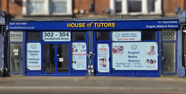 Tutor helping small group of children in bright classroom